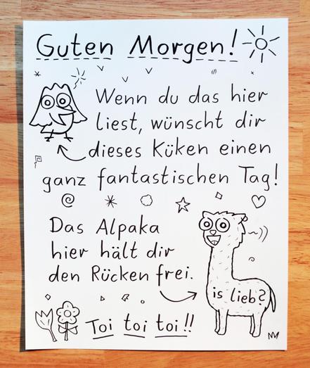 Abfotografiertes Blatt mit Text und Krakelzeichnungen. "Guten Morgen! Wenn du das hier liest, wünscht die dieses Küken (Zeichnung) einen ganz fantastischen Tag! Das Alpaka hier (Zeichnung) hält dir den Rücken frei. Toi toi toi! Is lieb?
