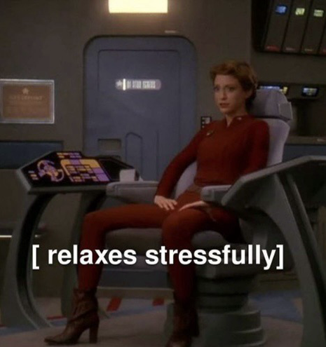 Major Kira from deep space nine sitting on the bridge of the defiant looking tense 