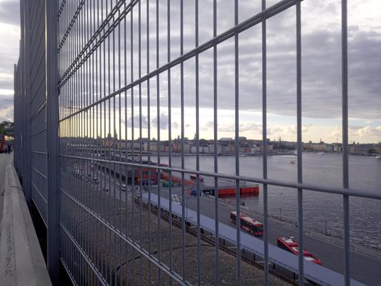 View of Stockholm Old Town seen through a steel grid fence that is covering the whole picture.