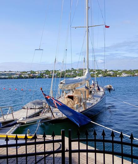 Stern view of a moored dark blue very large traditional sloop, J-Class yacht Velsheda, on a sunny day.