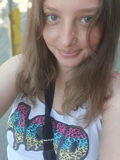 Kobieta w koszulce z napisem ACID, uśmiecha się do kamery