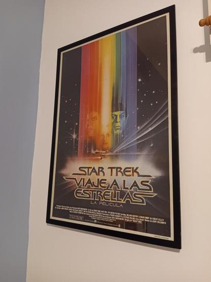Theatrical poster for Star Trek: The Motion Picture, on a black frame and hanged on a white wall. The title is given both in English, as just 'Star Trek', followed by the Spanish 'Viaje a las Estrellas: La Pelicula'.