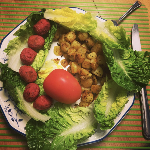 Fresh lettuce and tomato together with seasoned baked potatoes and beetroot balls