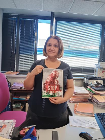 Una mujer con un cartel en el que se lee el lema STOP GENOCIDIO.
