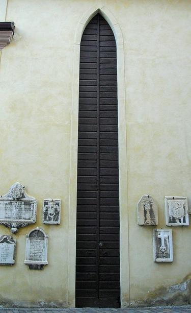 During festivities, the church square is decorated with heavy, wooden flagpoles. Because the poles are so heavy, lifting them for each event would be impractical. A tall doorway opens into a high-ceilinged storage room, allowing two people to carry the flagpoles in and store them upright.