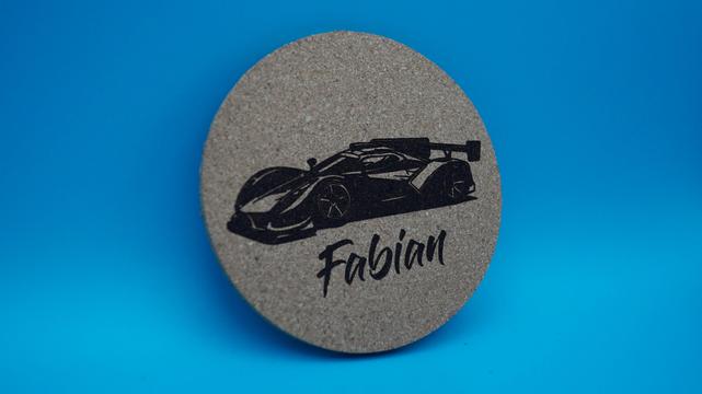 Korkuntersetzer mit coolem Sportwagenmotiv und graviertem Namen „Fabian“, leicht angewinkelt dargestellt.