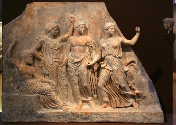 Marble relief of Zeus, who is seated, while Leto stands by his left side with their children Apollon and Artemis.