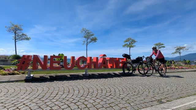 Les lettres #Neuchâtel en bord de lac avec Céline en vélo