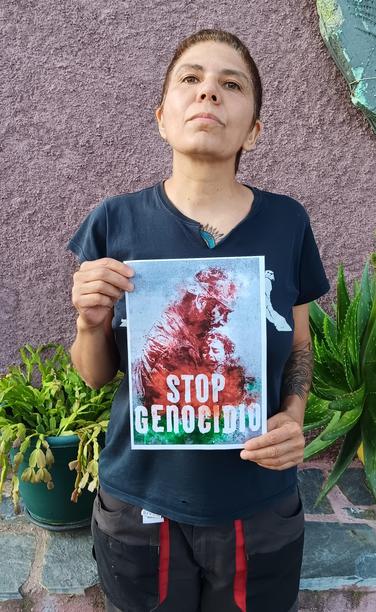 Una mujer sosteniendo un cartel con el lema STOP GENOCIDIO.
