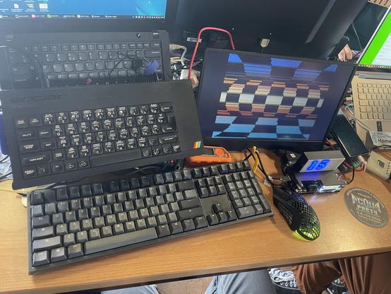 Computer setup at a demoparty with a sinclaire computer and several other computer (keyboards).