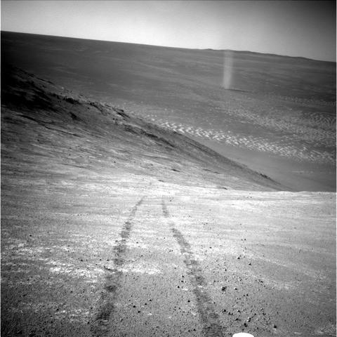 A black and white image of Marathon Valley in Endeavour Crater, captured by the Opportunity rover. This historic picture records a dust devil twisting through the valley in thee distance, with the tracks of the rover in the foreground.
Apr. 1, 2016 (Sol 4332). 
Credit images: NASA/JPL-Caltech