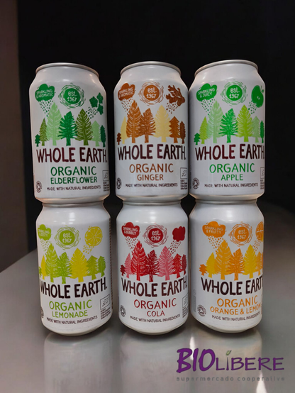 Seis latas de refrescos orgánicos "Whole Earth" están dispuestas en dos filas de tres. Cada lata muestra un diseño diferente con ilustraciones de árboles y frutas, indicando el sabor: flor de saúco, jengibre, manzana, limonada, cola y naranja y limón. Todas las latas indican que están hechas con ingredientes naturales y que la marca existe desde 1967. Al pie de la imagen se ve el logo de "Biolibere supermercado cooperative".