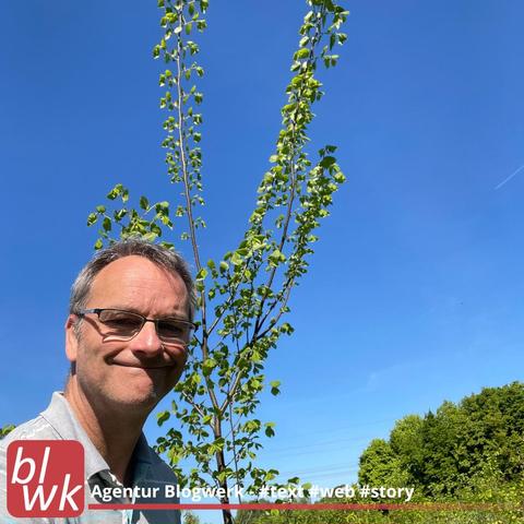 Klimawald in Selm, Oliver Hübner mit einem ca. 3 Meter hohen Baum