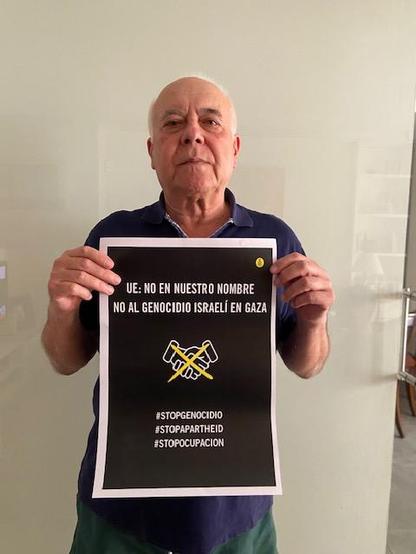 Un hombre sosteniendo un cartel con el texto UE: NO EN NUESTRO NOMBRE 
NO AL GENOCIDIO ISRAEL EN GAZA 
#STOPGENOCIDIO
#STOPAPARTHED
#STOPOCUPACION
