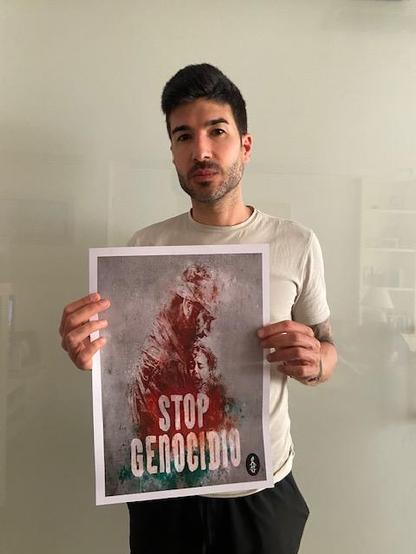 Un hombre sosteniendo un cartel con el texto STOP GENOCIDIO
#STOPGENOCIDIO
#STOPAPARTHED
#STOPOCUPACION
