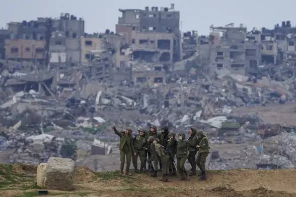 Israeli female soldiers taking a selfie with the background of bombed Gaza houses on February 19, 2024.