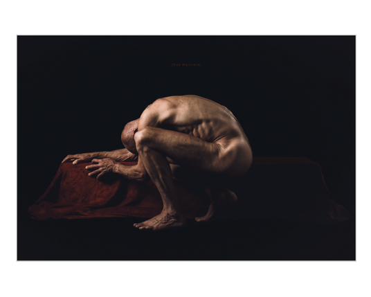 Artistic nude photograph by Gus Martinié titled "Resilient Flesh", featuring a male figure crouched in a contorted pose on a red draped surface. The scene is lit with soft, directional lighting that accentuates the tension in the muscles and the texture of the skin, set against a deep black background. The composition conveys a powerful and dramatic contrast between fragility and endurance.