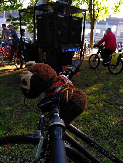 Plüsch-Elch Gunvald auf dem Fahrradlenker, dahinter mehr Menschen mit Fahrrädern und die die dicke Soundbike-Anlage von Critical Bass. 