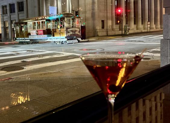 outbound California Street cable car passing through the intersection of Montgomery and California. Manhattan cocktail on the side.
