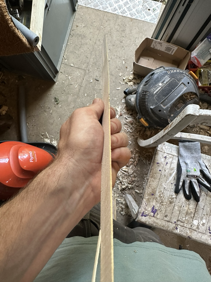 My hand holding a 1mm slice of wood from the plank