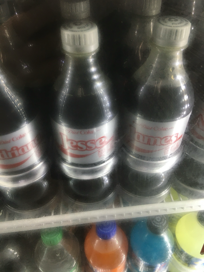 two “share a coke” bottles of Diet Coke in a freezer. one is labeled “Jesse” while another is labeled “James”.