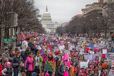 Color photo of an Anti-Trump protest in Washington D.C., with the U.S. Capitol building in the background