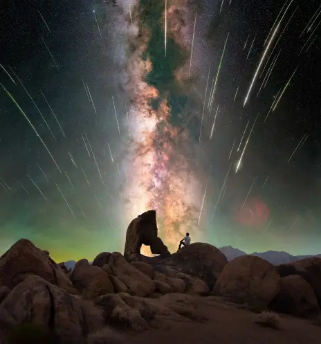 Composite picture of Perseid shower at Boot Arch, Sierra Nevada, with a human figure in the centre and Milky Way in the background. 