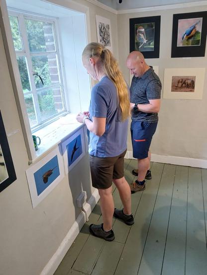Members of the Royal Wootton Bassett Camera Club mounting photographic prints to the walls of the gallery at the Richard Jefferies Museum.
