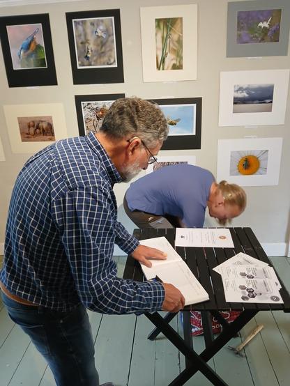 Members of the Royal Wootton Bassett Camera Club setting up an information area in their exhibition in the gallery of the Richard Jefferies Museum.