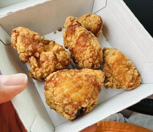Five large golden chicken nuggets sitting in a fast food container