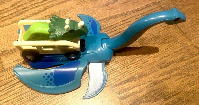 A toy Triceratops in a wagon, on a ferry Plesiosaurus 