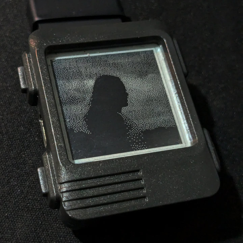 Watchy e-ink watch showing the silhouette of a woman. 