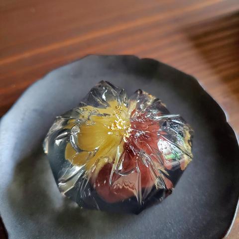 Hotaru-no-yoru, a jelly sweet wrapped around coloured bean paste. Small pieces of gold leaf mimic fireflies above water.