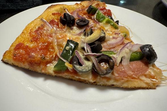 A slice of pizza on a plate.