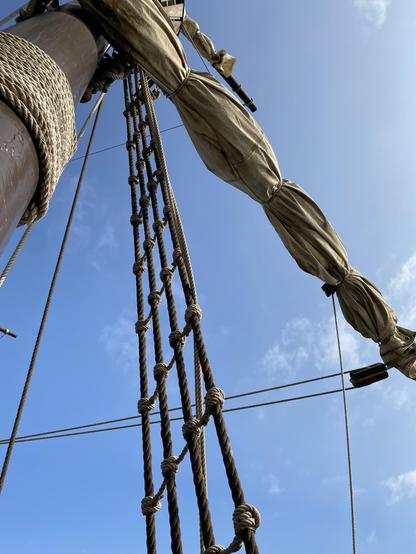 Foto del detalle de las jarcias y velas amarradas de un barco de vela antiguo, concretamente una réplica de la Nao Victoria