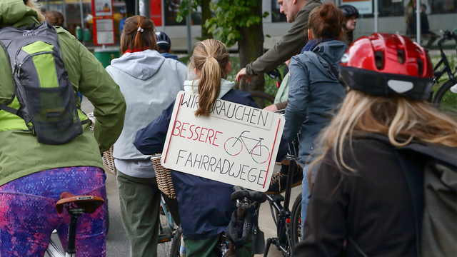 Foto von der Sternfahrt NRW 2025: Viele Radfahrende fahren mit, im Zentrum des Fotos ist eine Person auf dem Fahrrad mit einem Demoschild. Aufschrift: "Wir brauchen bessere Fahrradwege".