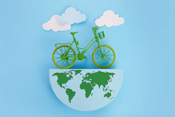 Un vélo vert qui roule sur le globe sur un fond bleu ciel et de nuages au-dessus