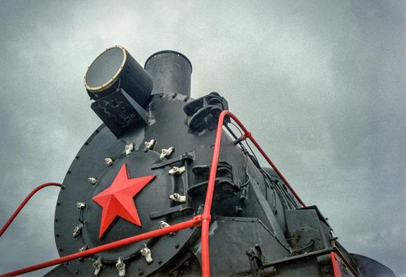 The photo shows the front part of a Soviet steam locomotive with a red star. The locomotive itself is black.