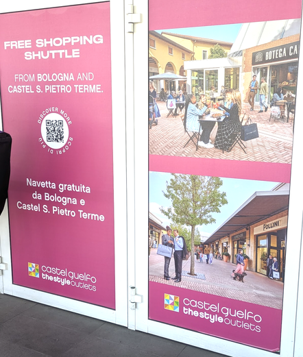 Ad in Bologna train station for free shopping shuttle, showing people sitting in piazzas.
