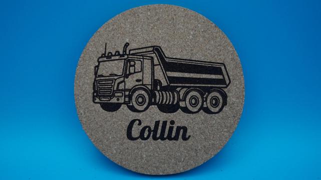 Frontalansicht eines gravierten Untersetzers mit LKW-Motiv und dem Namen „Collin“, auf hellbraunem Korkmaterial.