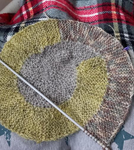 Un debut de tricot en spirale gris et vert