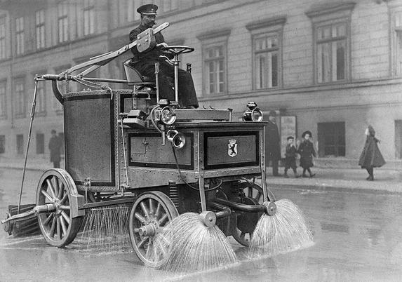 Barredora cuyo cuerpo son dos cajas sobre la que se sienta el conductor, que tiene un volante colocado perpendicularmente la suelo. Las ruedas tienen radios gruesos. Por delante dispositivos frente a las ruedas que expulsan agua como un aspersor. Entre las ruedas delanteras y traseras tiene otro que derrama una cortina de agua y detrás tiene un rodillo que puede elevarse con una palanca al alcance del conductor.