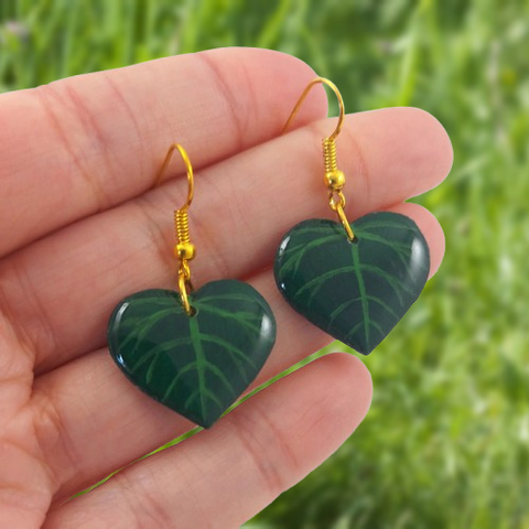 Boucles d'oreilles fantaisie pendantes éco-responsables en forme de feuilles vertes foncées cordiformes (en forme de cœurs).
Les perles sont réalisées en CD recyclé, découpées et peintes à la main, puis recouvertes de résine époxy.
Les attaches sont en laiton doré, mais sont aussi disponibles dans d'autres métaux et coloris.