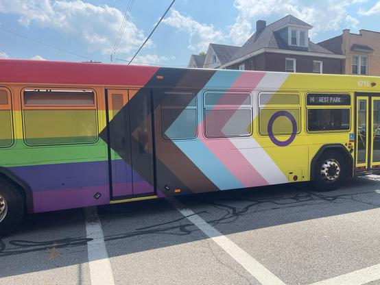 A Pittsburgh Regional Transit bus with the intersex-inclusive Progress Pride Flag design covering it. 