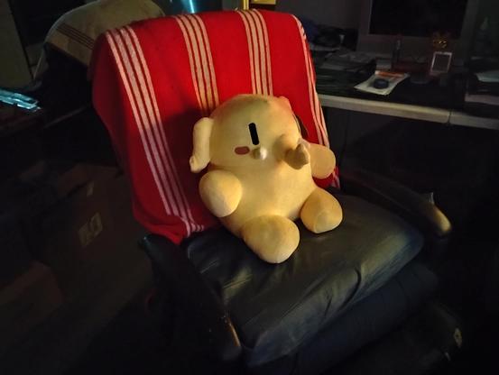 A photo of the Plushtodon placed in the chair in which its owner usually sits.