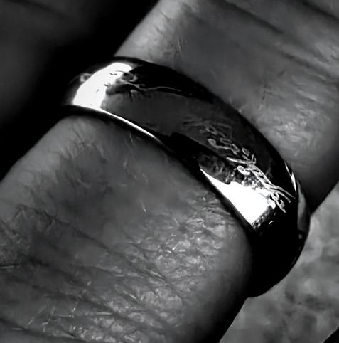 Ein Finger mit dem Einen Ring aus Der Herr der Ringe (Schwarz-weiß-Foto)