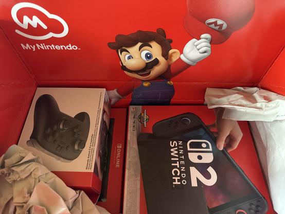 Bild der Switch 2 im Versandkarton von Nintendo. Der Versandkarton ist innen mit einem Mario-Motiv bedruckt.