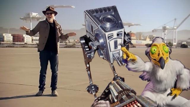 The image features a man in a hat standing in an outdoor setting with industrial structures in the background. Next to him is a robotic figure resembling a droid and a cartoonish creature with distinctive features pointing. The scene blends real and animated elements.