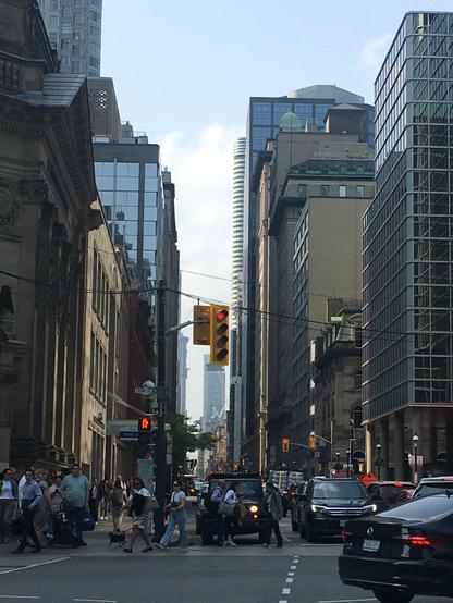 A bustling city street filled with cars and pedestrians navigating through the urban environment.