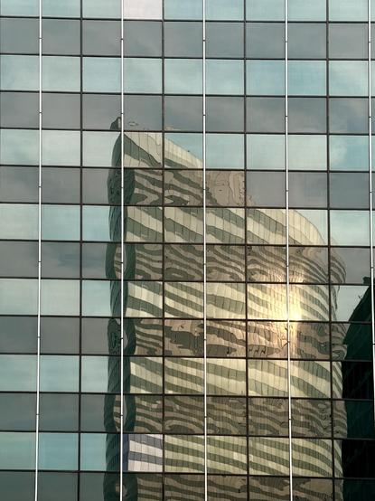 One of The Towers at Rosslyn reflected in the windows of another building. The sun is bouncing off the reflected image. 